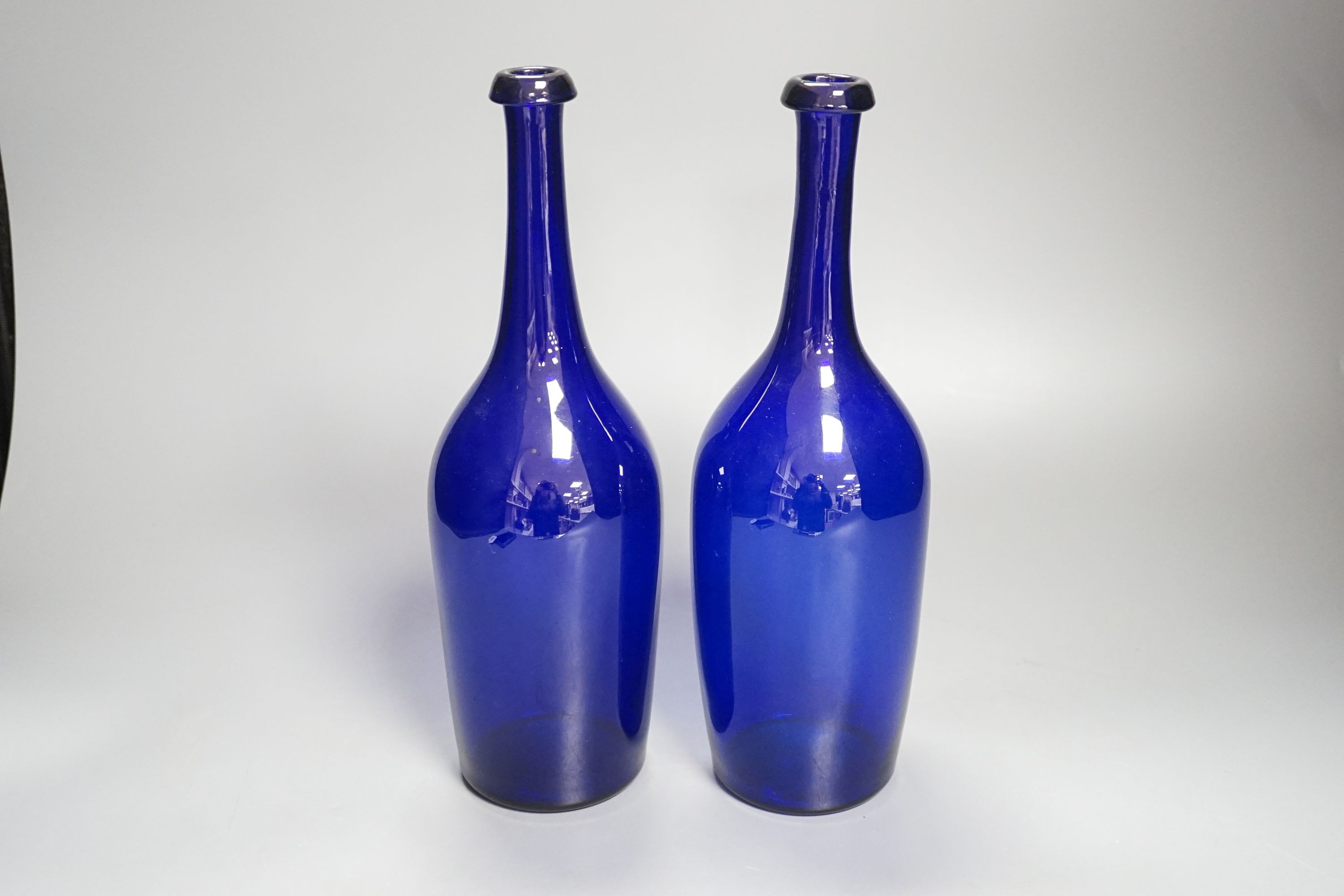A pair of 19th century blue glass bottles 29cm